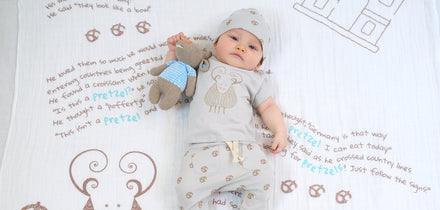 Image of baby on a blanket with a plush toy