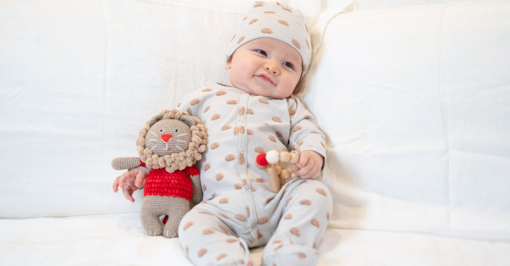 Image of smiling baby holding plush toy
